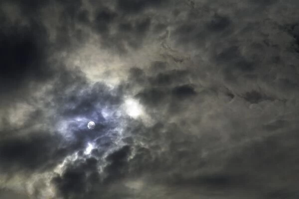 Sun behind layer of cloud, low angle view