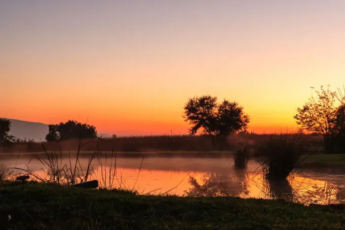 Framed Print : The sun rises over a small dam in the high veld winter landscape near Hartebeespoort, South Africa