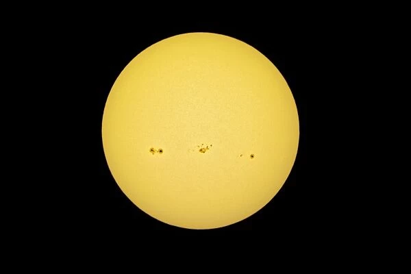 Sun with solar spots in the white light, yellow filter