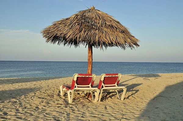 Empty sunbeds under a parasol on the beach of Playa Ancon near Trinidad, Cuba, Caribbean