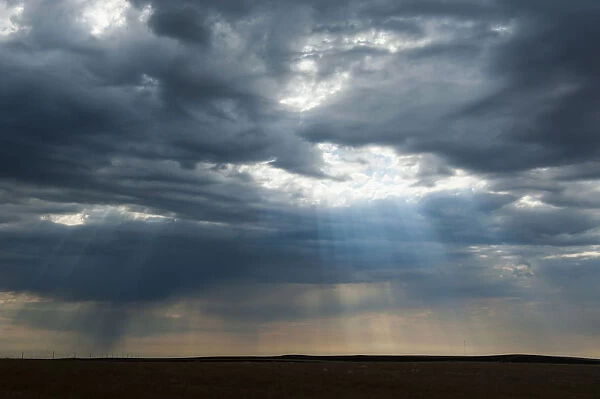 Sunlight breaking through dark clouds near Minuteman nuclear missile site, South Dakota, USA