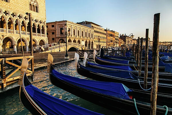 Sunrise view on gondola station near Piazza San Marco with Palazzo Ducale (Doges Palace) on a background