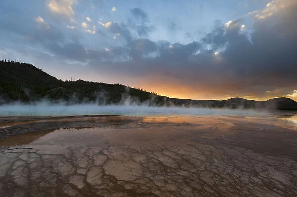 Sunset with steam rising from Grand Prismatic Spring, Yellowstone National Park, Wyoming, USA