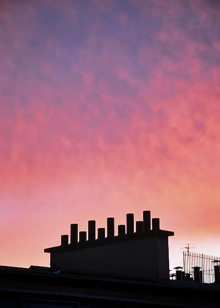 Sunset over a typical chimney in Paris, France
