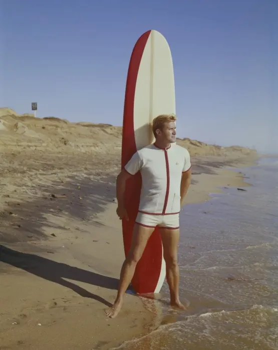 Framed Print : Surfer holding surfboard on beach