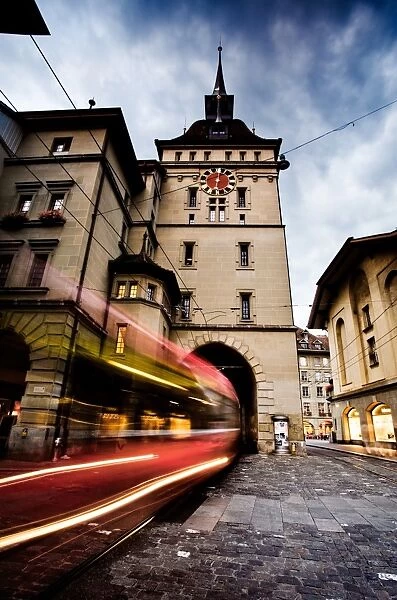 Swallowed. A tram passes under a clock tower in Bern Old Town, Bern, Switzerland