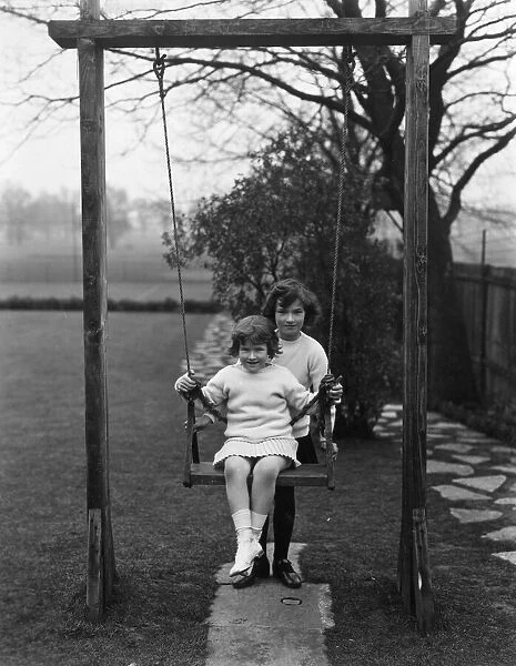 Swing Fun. circa 1930: Two children playing with a swing