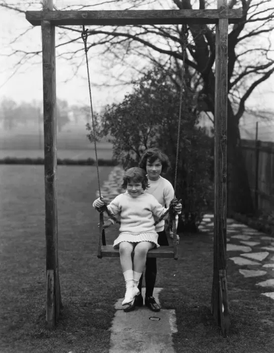 Framed Print : Swing Fun. circa 1930: Two children playing with a swing
