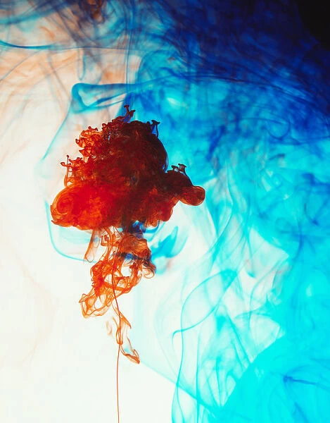 Swirls of floating orange and blue ink in liquid