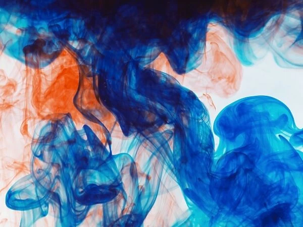 Swirls of orange and blue ink in liquid
