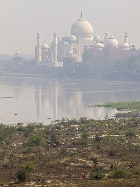 Taj Mahal. A view of Taj Mahal from Yamuna river where some people are walking