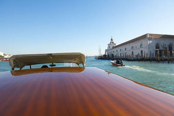 Taxi boat on Grand Canal and old customs building in Venice, Italy