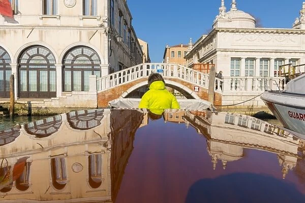 Taxi boat on Grand Canal and old buildings reflected on the boat roof in Venice, Italy