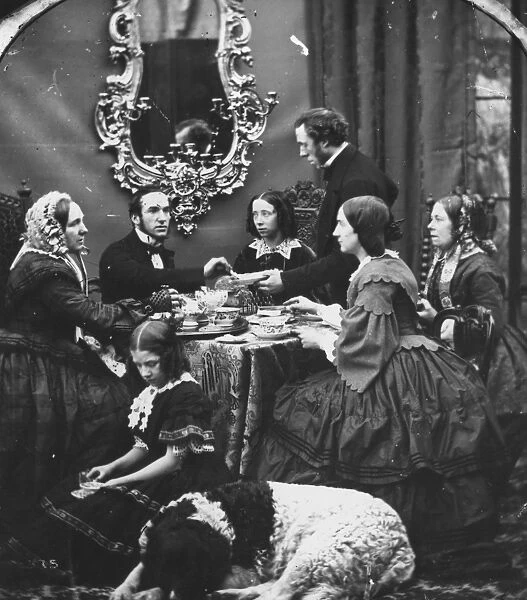 Tea Time. circa 1865: A middle class family take tea while a St Bernard