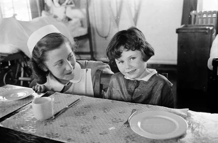 Framed Print : Teatime. 17th September 1955: A nurse sits a little girl down to table Framed Print : Teatime. 17th September 1955: A nurse sits a little girl down to table