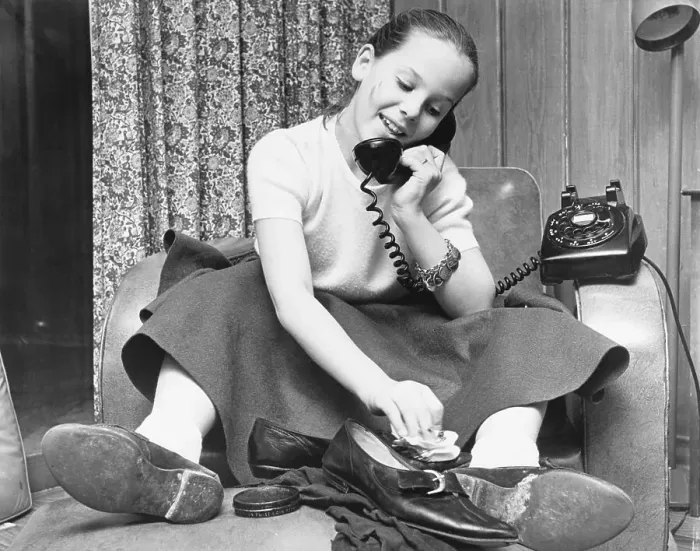 Framed Print : Teenage Girl Talks on Phone While Polishing Shoes