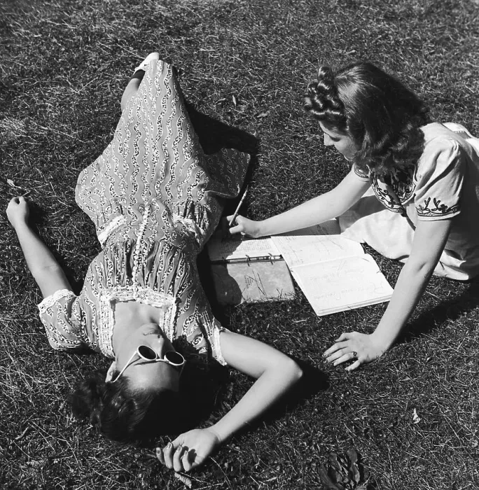 Framed Print : Two teenage girls (14-16) on grass, one doing homework (B&W) Framed Print : Two teenage girls (14-16) on grass, one doing homework (B&W)