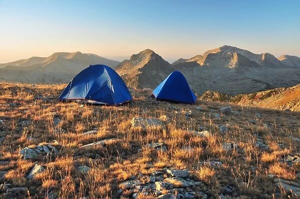 Two tents in a mountain at sunrise