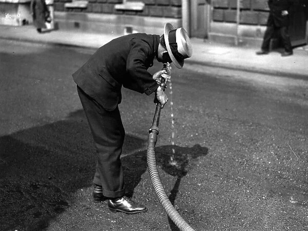 Thirsty. 5th June 1925: An office boy drinking