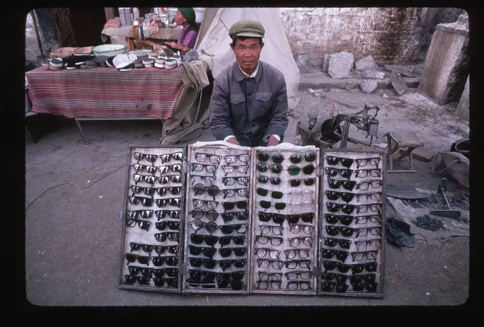 Framed Print : Tibetan Merchant Selling Sunglasses Framed Print : Tibetan Merchant Selling Sunglasses