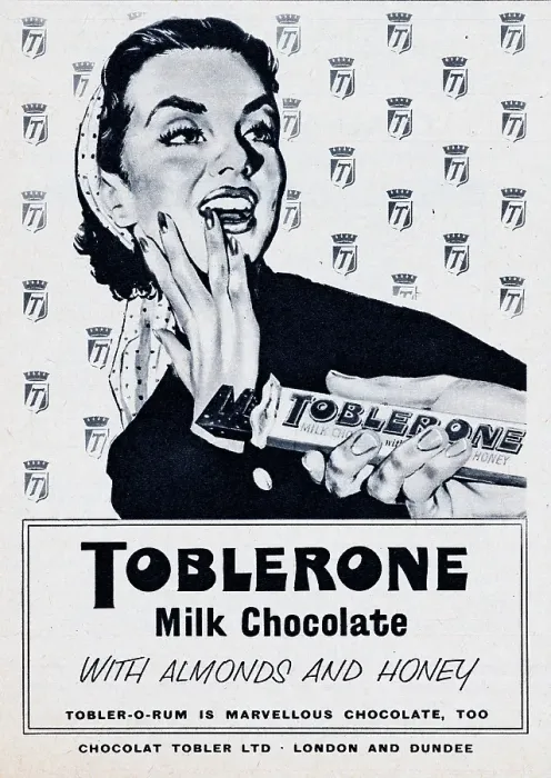 Framed Print : Toblerone. 1957: A man offers a woman a piece of a Toblerone chocolate bar Framed Print : Toblerone. 1957: A man offers a woman a piece of a Toblerone chocolate bar