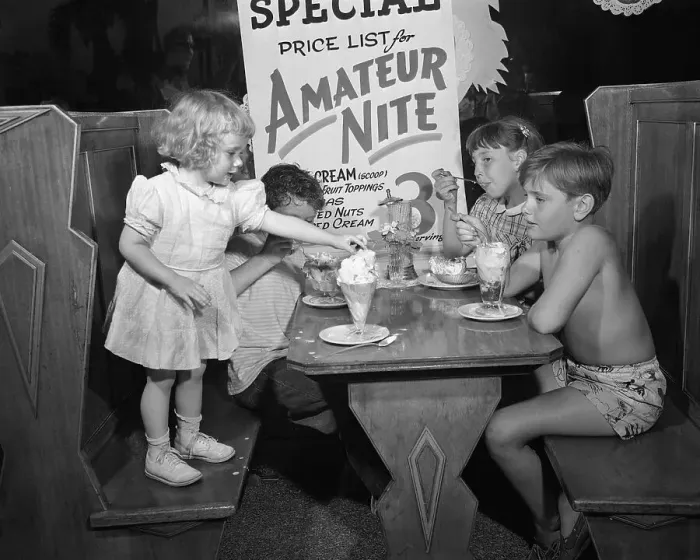Framed Print : Toddler (2-3 years) and children (10-12 years) eating icecream at booth table. Los Angeles, California, USA. July 02, 1948 Framed Print : Toddler (2-3 years) and children (10-12 years) eating icecream at booth table. Los Angeles, California, USA. July 02, 1948