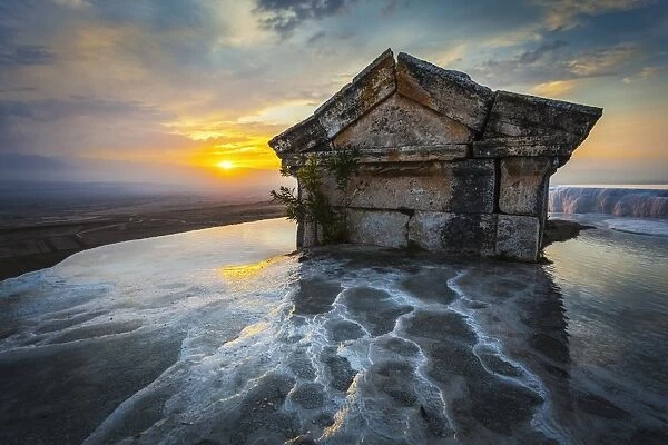 Tomb submerged in a travertine pool in Hierapolis at sunset