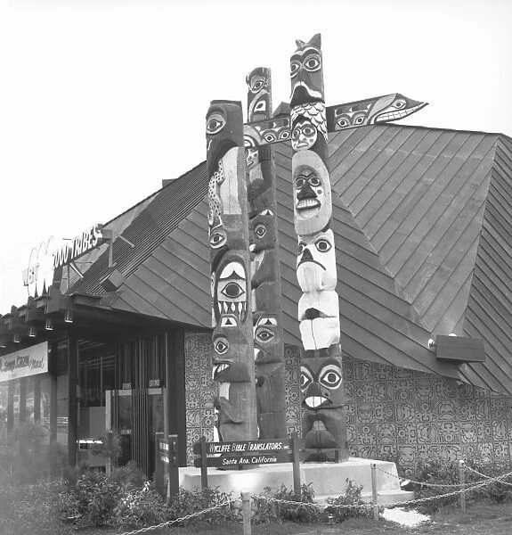 Totem poles at building, (B&W)