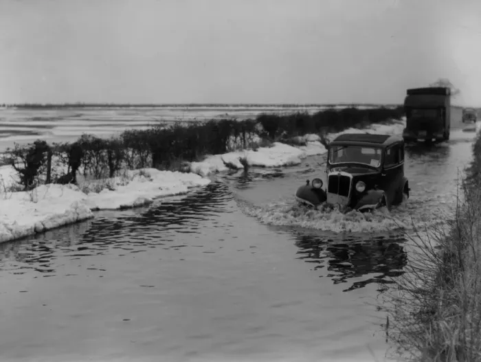 Framed Print : Thaw. 11th March 1947: Traffic plowing through water on a flooded road Framed Print : Thaw. 11th March 1947: Traffic plowing through water on a flooded road