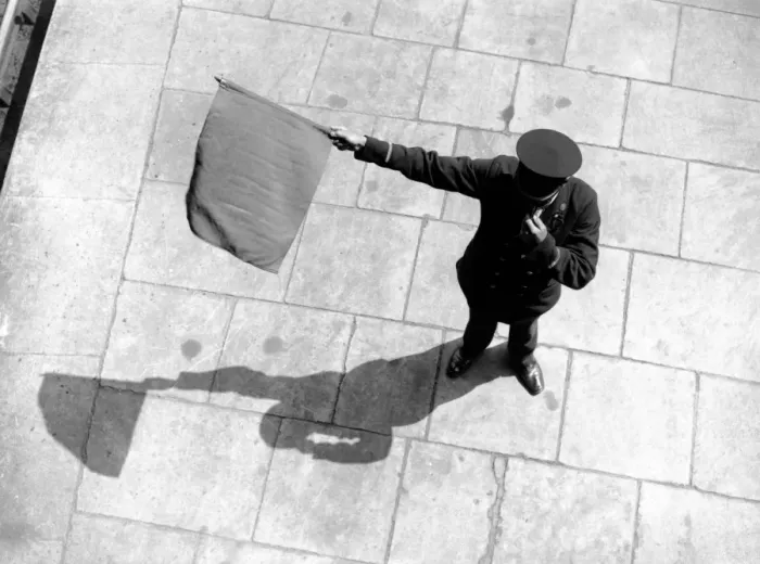Framed Print : Train station guard waving flag