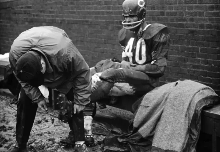 Framed Print : Trainer Cleans Gale Sayers Spikes During Football Game Framed Print : Trainer Cleans Gale Sayers Spikes During Football Game