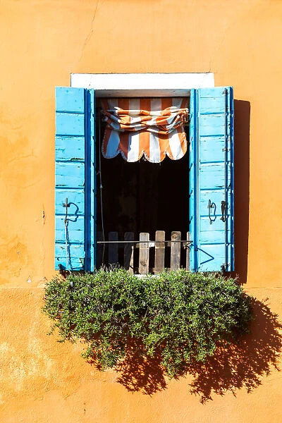 Typical ornate window of a colorful house in Burano, Venice