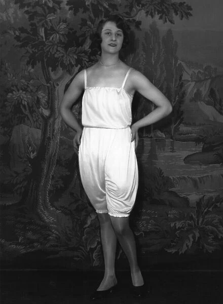 Underwear. circa 1928: A woman models underwear, against a painted back-drop