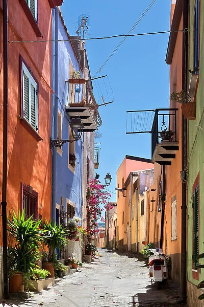 Uphill street with colourful architecture in Bosa, Sardinia, on a sunny day
