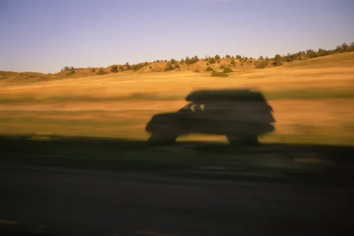 Framed Print : USA, Montana, SUV casting shadow on roadside, sunset (blurred motion)