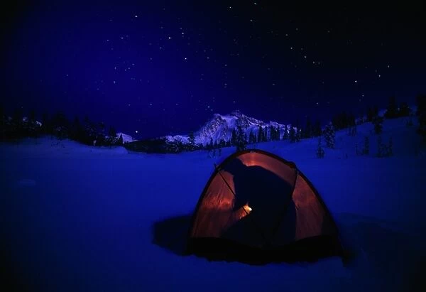 USA, Washington, Mount Baker, silhouette of man in tent on frozen lake