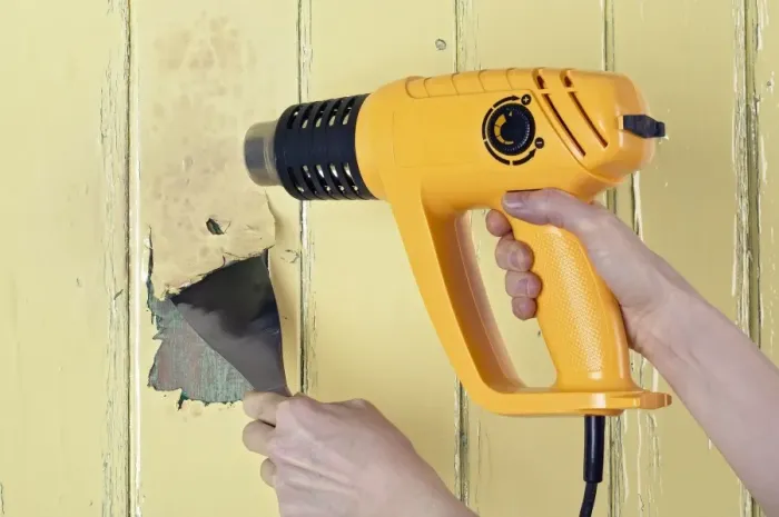 Framed Print : Using a heat gun and scraper to strip paint from a wooden surface Framed Print : Using a heat gun and scraper to strip paint from a wooden surface