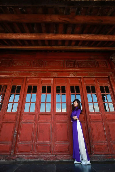 Vietnam Ao Dai - Vietnamese woman in Ao Dai traditional dress near red doors