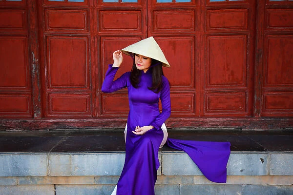 Vietnam Ao Dai - Vietnamese woman in Ao Dai traditional dress near red doors