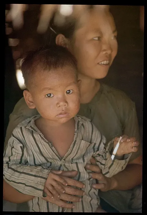 Framed Print : Vietnamese Child Smoking on Mother's Lap Framed Print : Vietnamese Child Smoking on Mother's Lap