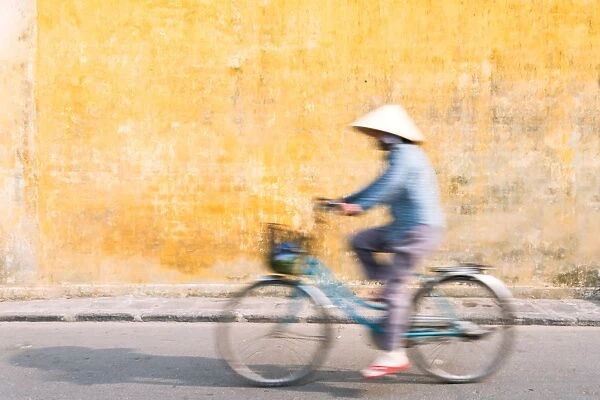 Vietnamese woman riding a bicycle in Hoi An