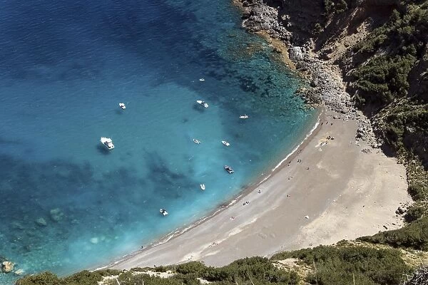 View on the beach Platja des Coll Baix, turquoise blue water, anchoring boats, peninsula