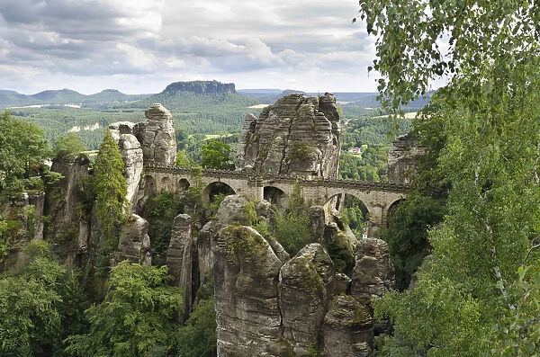 View of the rocks of the Bastei and the Basteibruecke bridge, behind Mt. Lilienstein, Elbe Sandstone Mountains, Saxony, Germany, Europe