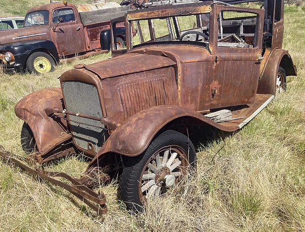 Vintage vehicles left to rot in a prairie scrapyard
