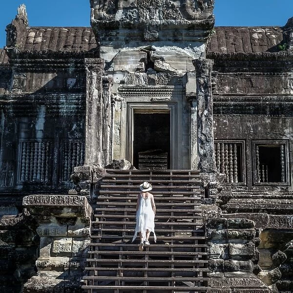 Visitors walk up the stairs of Angkor Wat