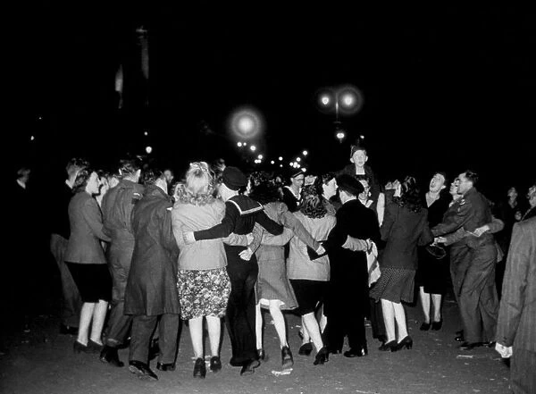 VJ Day. 11th August 1945: Revellers dancing in a floodlit Trafalgar Square