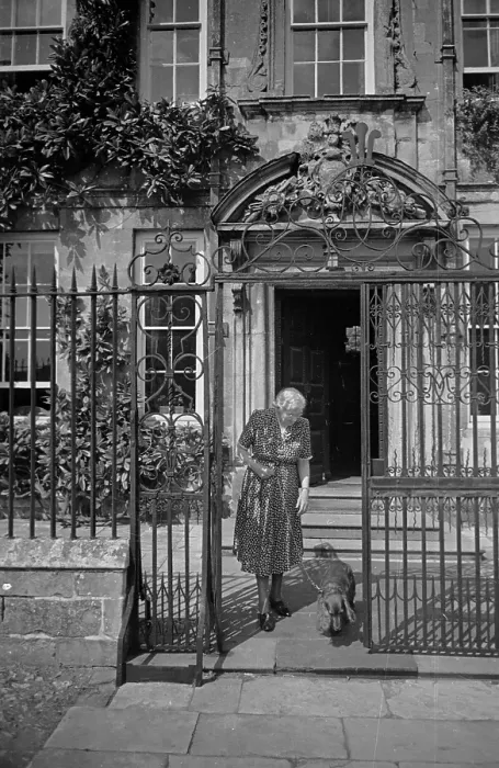 Framed Print : Walkies. 23rd July 1949: A woman leaves her house in Salisbury's Cathedral Framed Print : Walkies. 23rd July 1949: A woman leaves her house in Salisbury's Cathedral