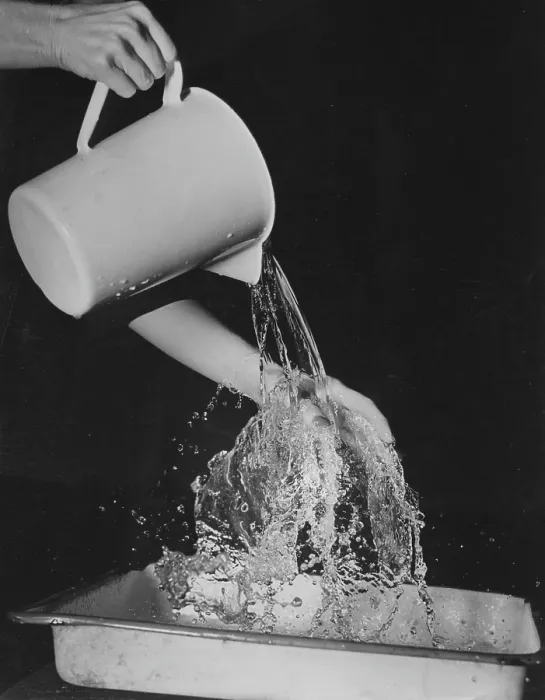 Framed Print : Water Jug. A close up of water being poured out of a water jug, circa 1940s Framed Print : Water Jug. A close up of water being poured out of a water jug, circa 1940s