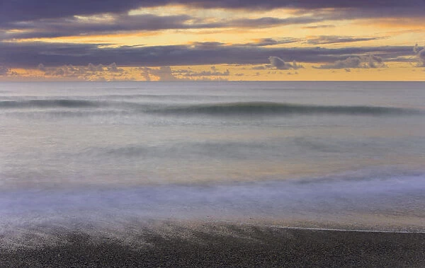 Waves breaking on beach, dusk