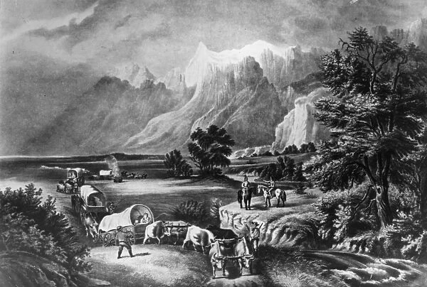 Westward. circa 1850: Emigrants in covered wagons approaching the Rockies